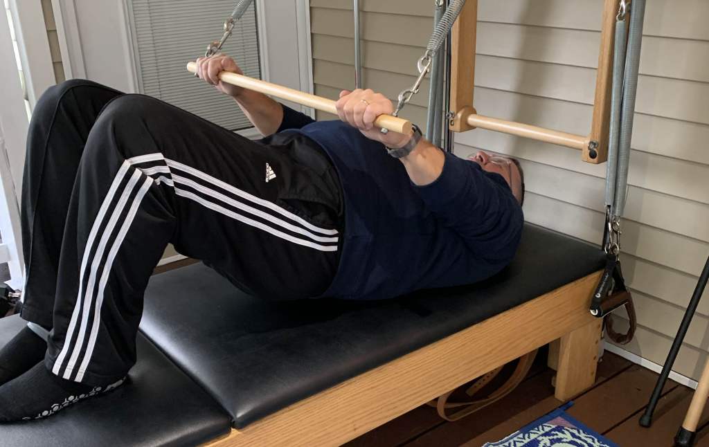 Middle aged man doing Pilates during a Private Pilates Session