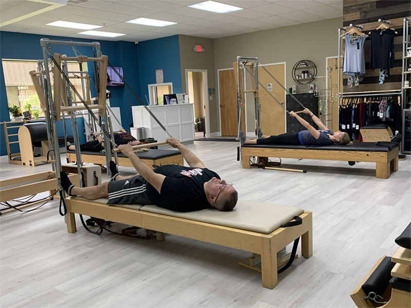 Middle-aged man doing Pilates in a small group Pilates class taught at Precision Pilates in Nesconset NY