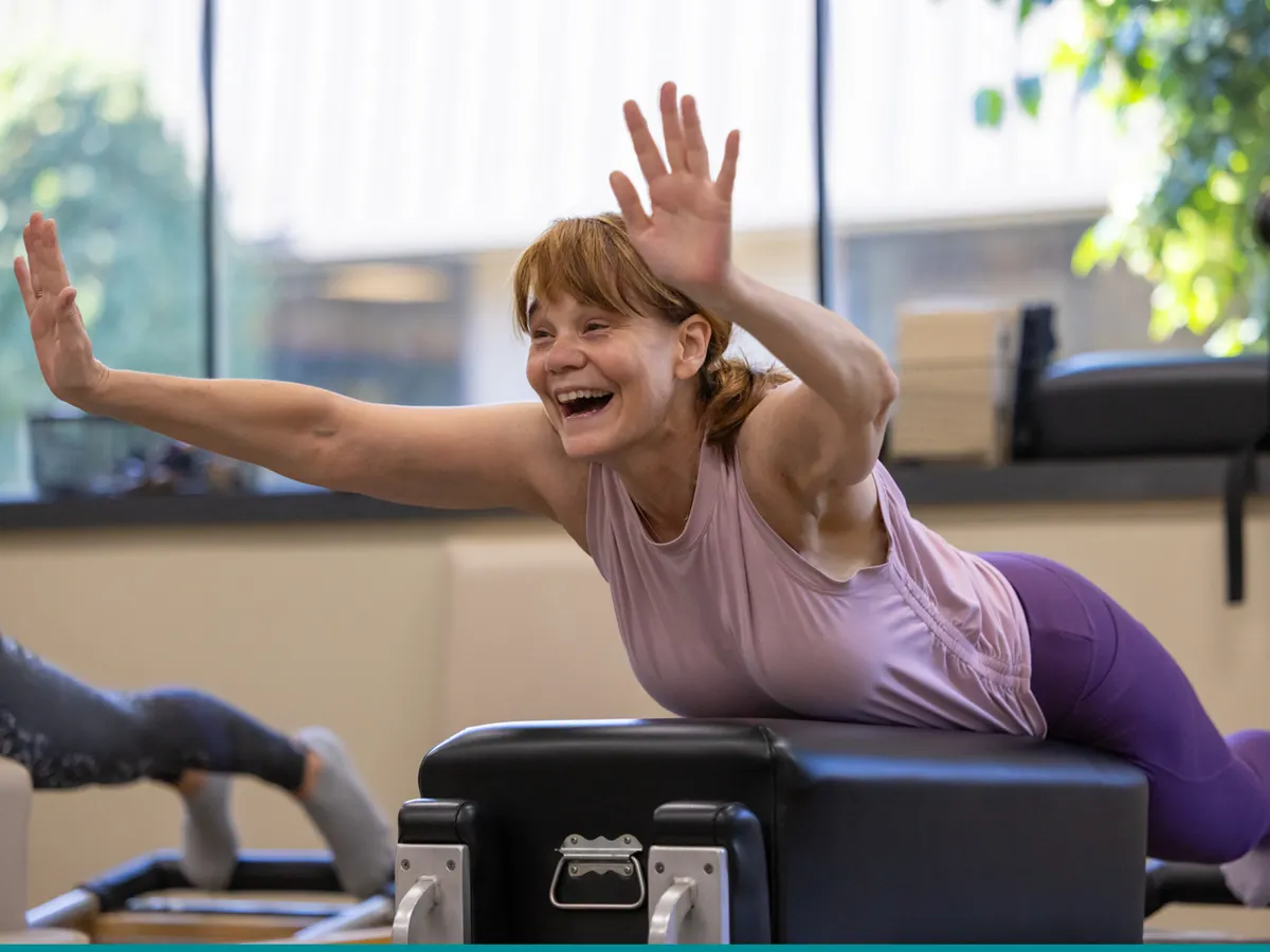 pilates-party-smithtown Happy Wowan trying a new exercise on the Reformer during a Pilates Party at Precision Pilates in Smithtonw